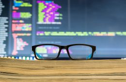 Image of pair of glasses in front of a computer screen,