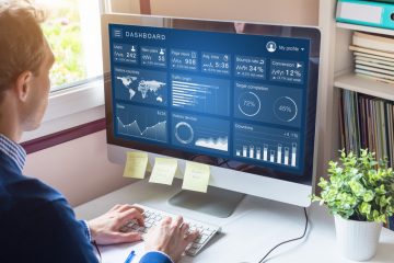 Image of man looking at metrics on computer screen